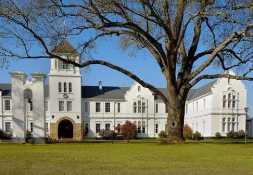 Hilton College, Top school Africa, Best boarding school, Historic white college building with central tower, arched entrance,