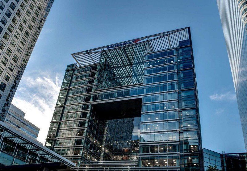 Modern glass corporate building with steel framework and high-rise surroundings