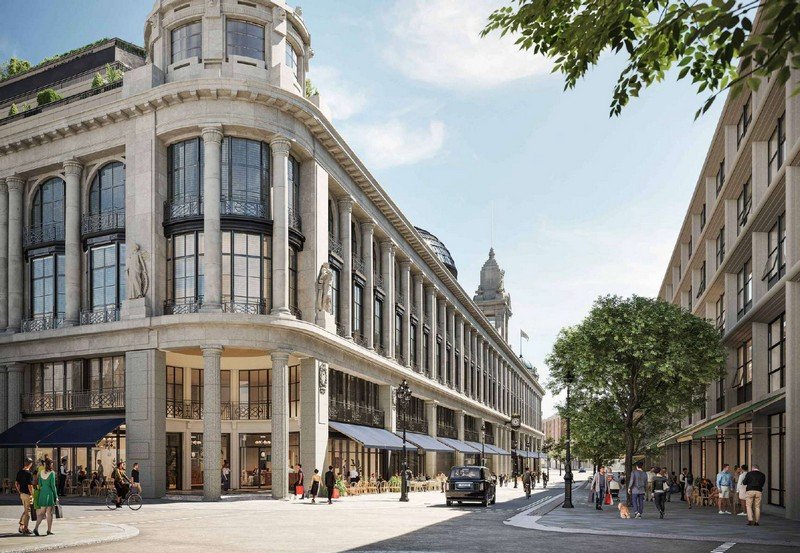 Grand multi-storey hotel building with stone columns, arched windows, and sunlit façade on a city street.